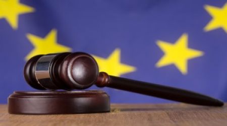 młotek sędziowski i flaga UE w tle